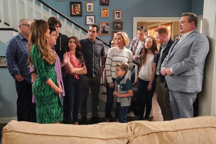 Elenco de la serie Modern Family dentro de una sala charlando con Sofía Vergara