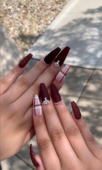 Chica con las uñas pintadas en colores guinda y en forma de ataúd