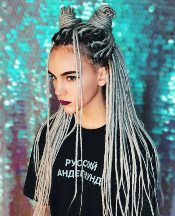 Looks con trenzas africanas; mujer de cabello largo y gris peinado en dos medios chongos altos