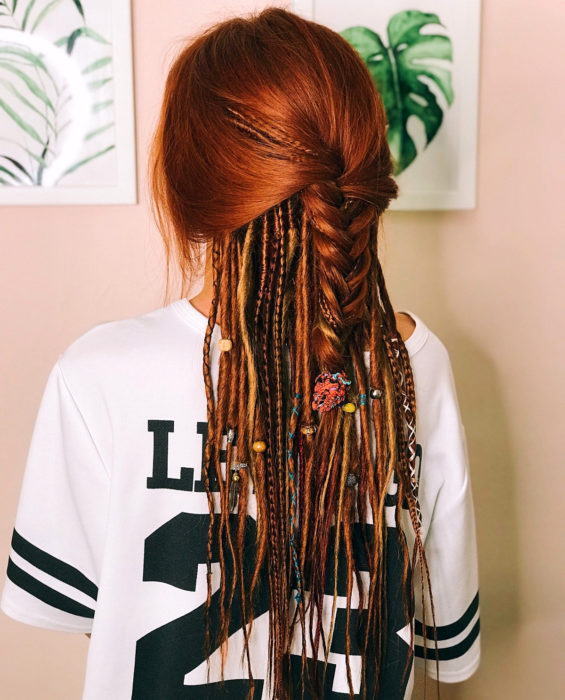 Looks con trenzas africanas; mujer pelirroja con peinado de media cola, con blusa deportiva de equipo de fútbol