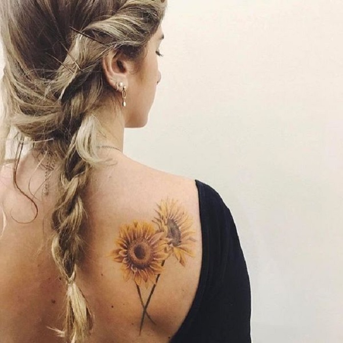 Tatuaje en la zona del hombro de un par de girasoles