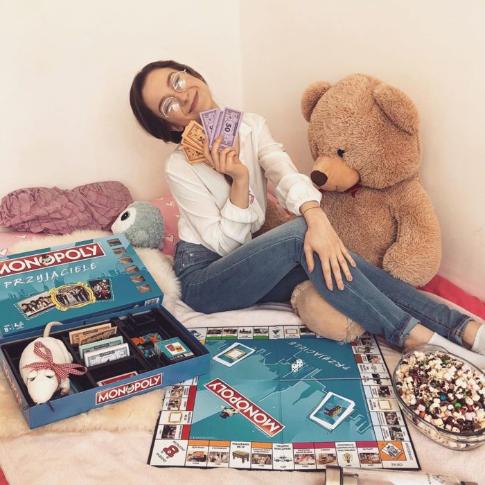 Chica jugando con un tablero de Monopoly en su cama