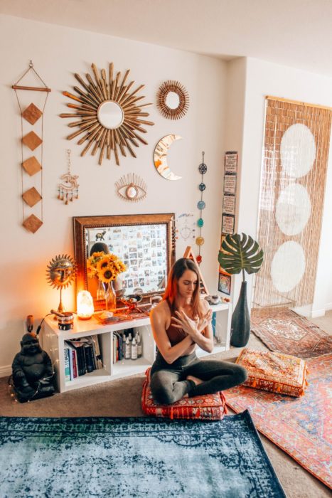 Chica meditando en un tapete frente a su computadora