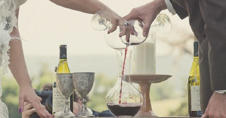 Pareja de novios bebiendo vino en una Ceremonia del vino