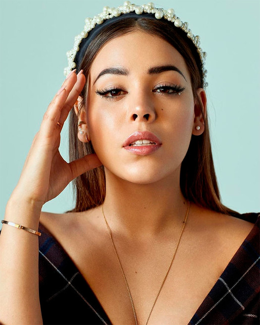 Danna Paola como Lu en la serie Elite usando una diadema de perlas 