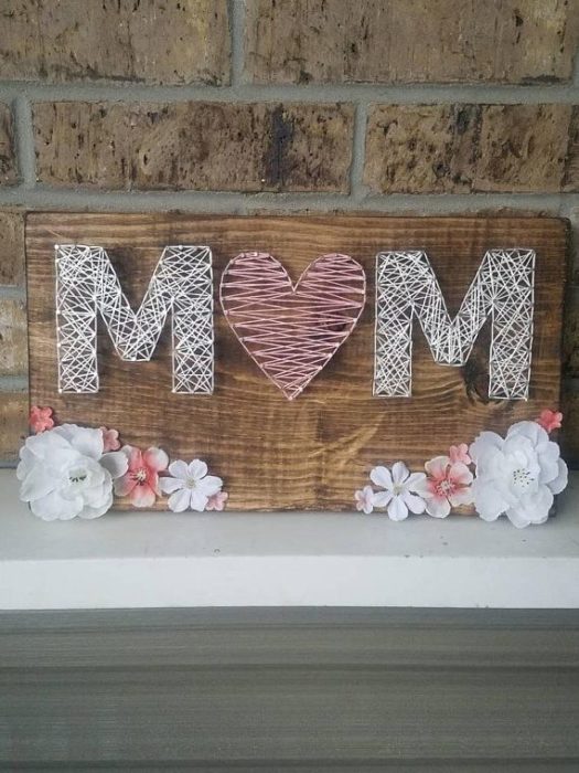 Tabla con clavos e hilo que forman la palabra mamá