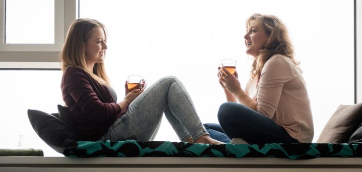 Madre e hija tomando té en la ventana 