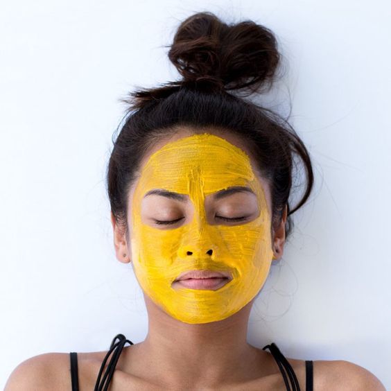 Chica con mascarilla de cúrcuma en el rostro