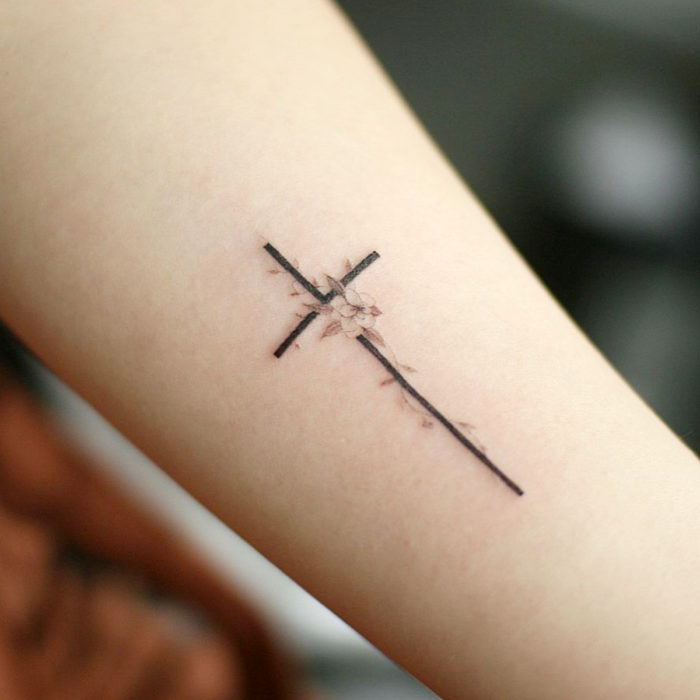 Tatuajes para regalarle a mamá el 10 de mayo; cruz con flores minimalista