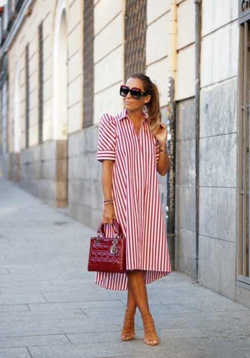 Chica usando un vestido holgado de color rojo con líneas blancas