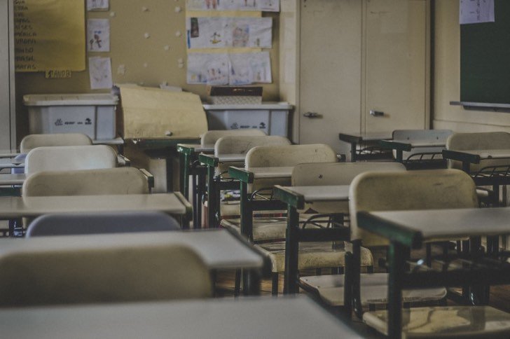 Aula de alumnos vacía con butacas acomodadas a los costados