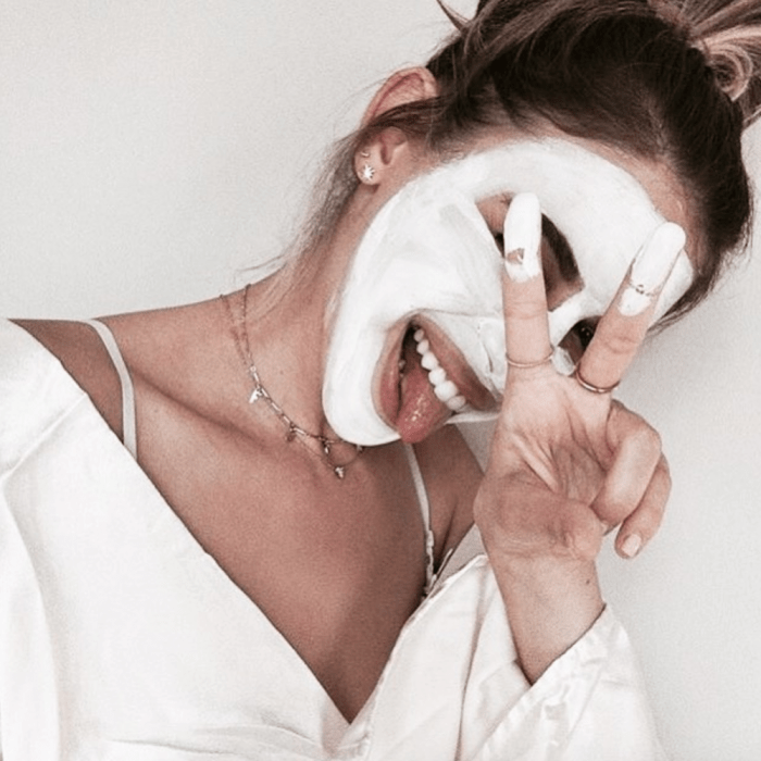 Chica haciendo señales y usando mascarilla blanca de arroz