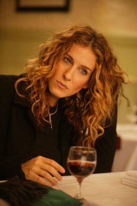 Carrie Bradshaw pensando mientras toma una copa de vino