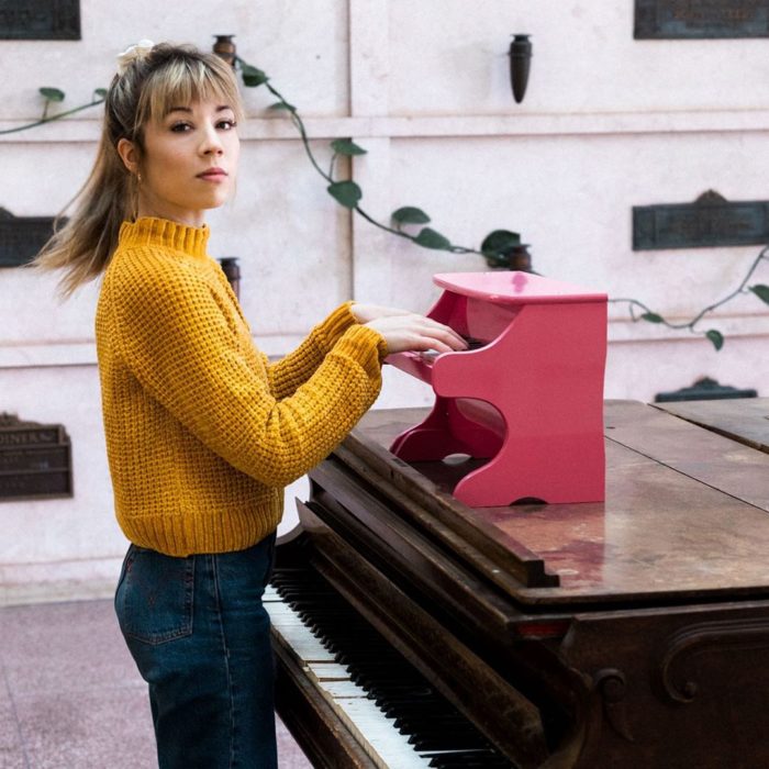 Jennette McCurdy tocando un minipiano rosa