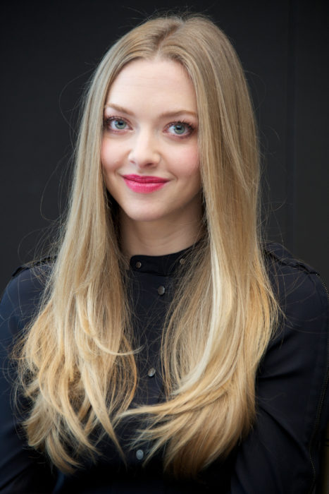 Amanda Seyfried posando con una blusa negra con glitter