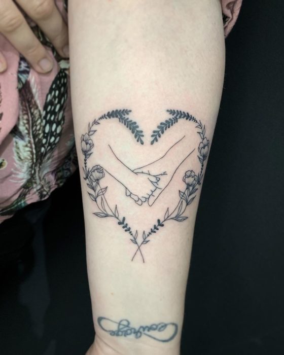 Tatuaje madre e hija, agarrándose las manos y un corazón alrededor de ellas