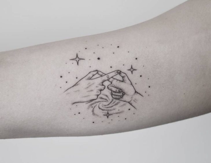 Tatuaje de madre e hija haciendo con los dedos el símbolo de infinito