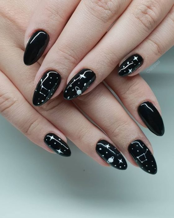 Manicura en color negro con diseño de estrellas en blanco