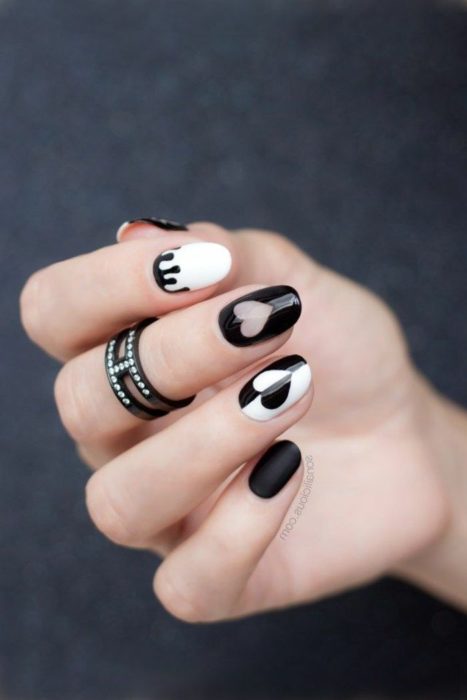 Manicura en color negro y blanco con un diseño de corazones