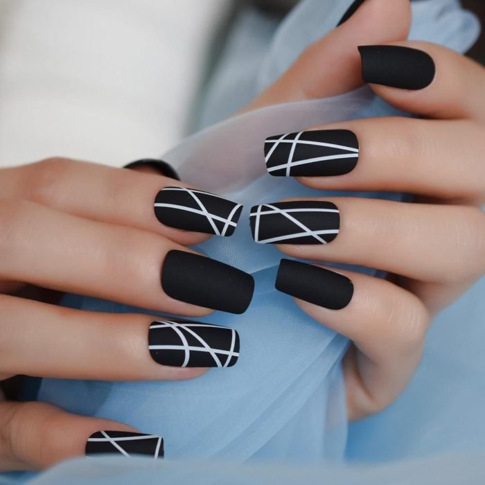 Manicura en color negro con líneas blancas