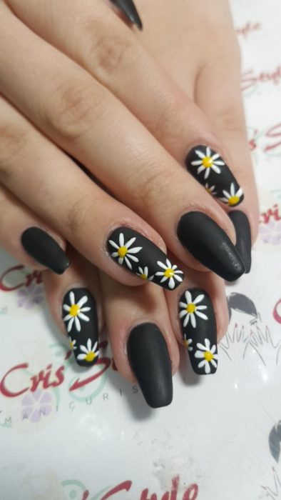 Manicura en color negro con diseño de margaritas y efecto mate
