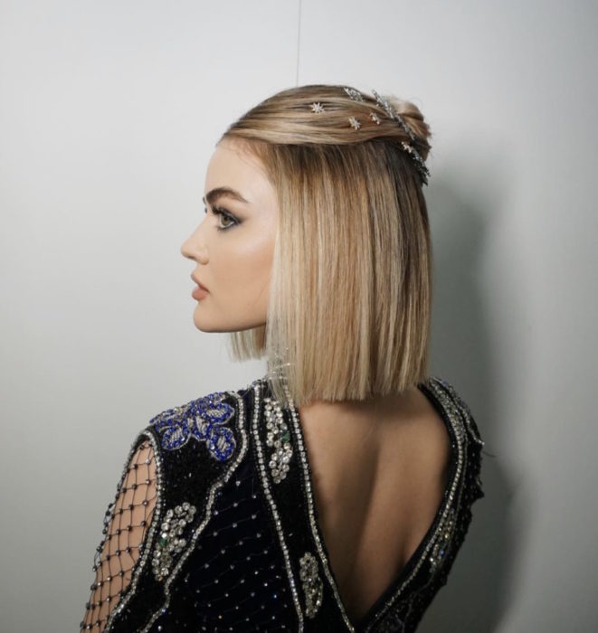 Lucy Hale con el cabello sujetado en una media coleta y con piedras decorativas