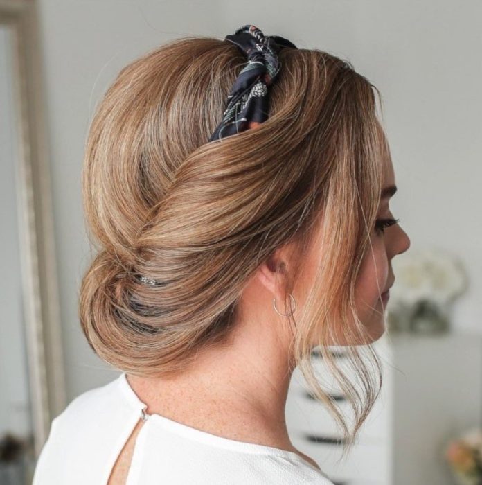Chica con el cabello corto recogido con una diadema en un chongo bajo