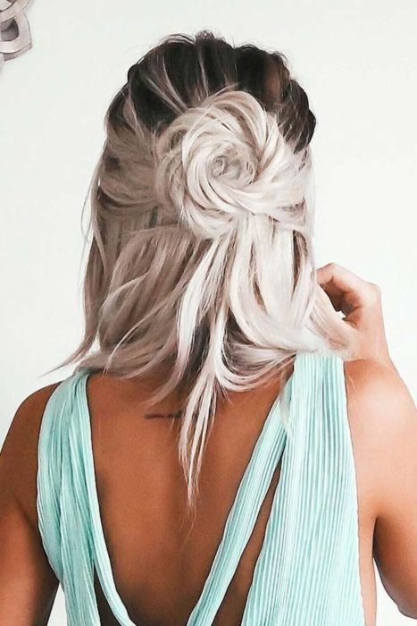 Chica con el cabello corto recogido con un chongo en forma de rosa