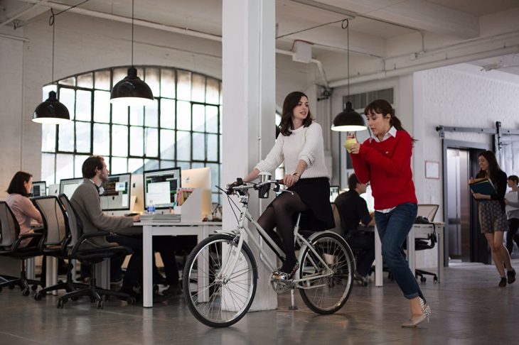 Escena de la película Pasante de moda, cuando Jules va en bicicleta en el pasillo del trabajo