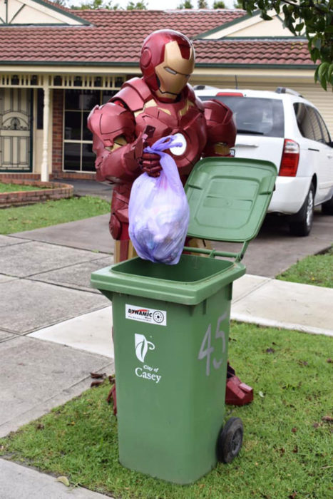 Señor vestido de Ironman listo para sacar la basura