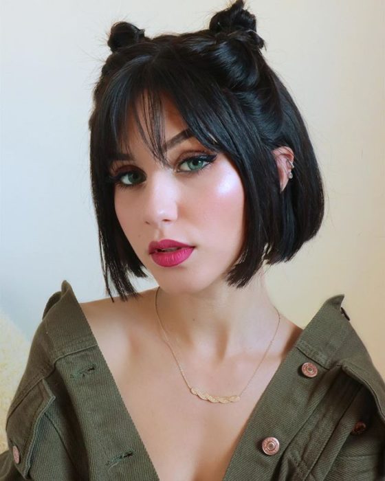 Chica con el cabello color negro sujetado en dos moñitos altos