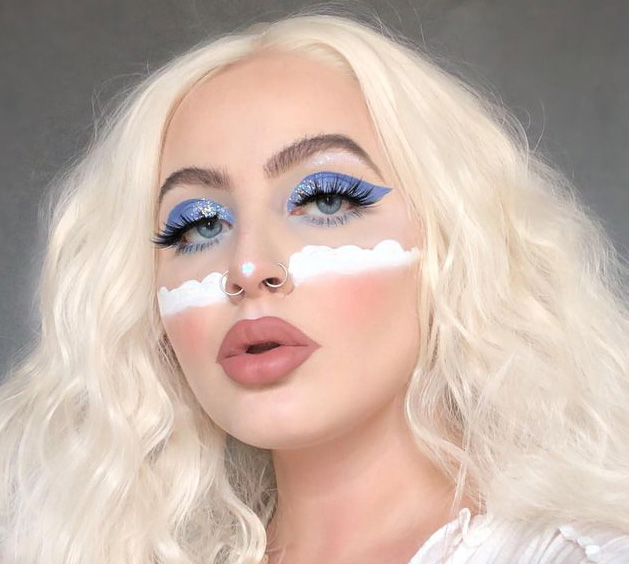 Chica rubia con sombra azul y nubes en las mejillas