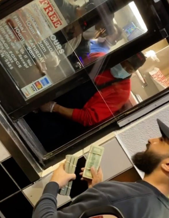 Hombre entrega dinero a empleados de restaurante de comida rápida
