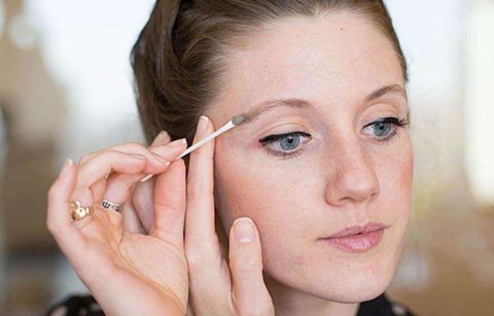 Mujer corrigiendo maquillaje con un hisopo