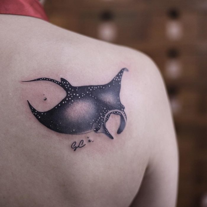 Chica con un tatuaje en forma de pez