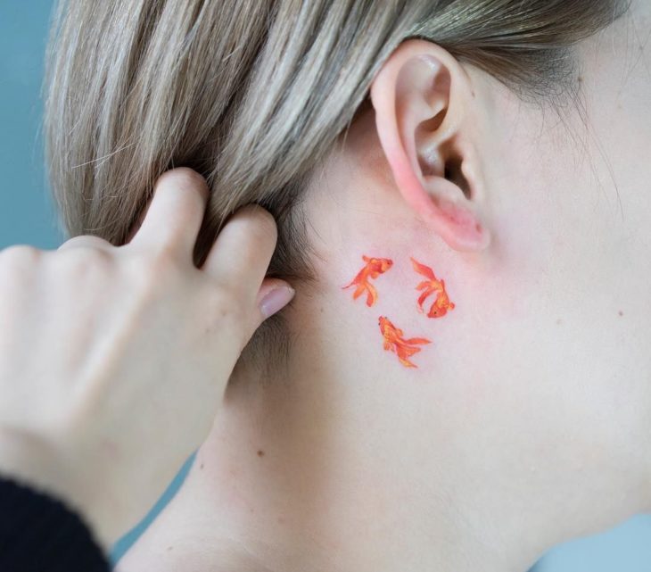 Chica con un tatuaje en forma de peces que forman un círculo
