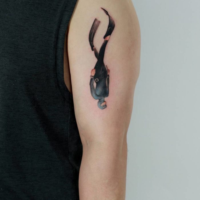 Chica con un tatuaje en forma de buzo con traje