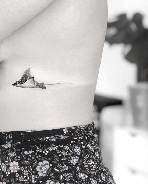 Chica con un tatuaje en forma de mantarraya