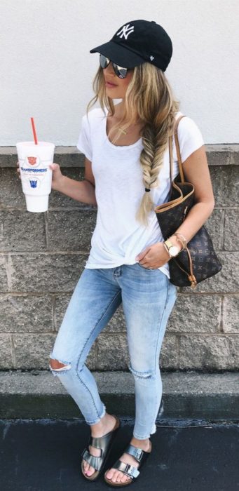 Chica usando skinny jeans con blusa blanca y gorra de béisbol