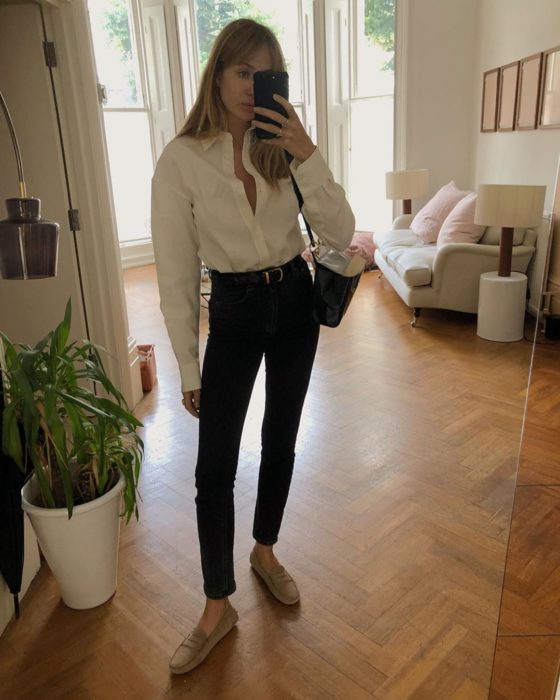 Chica usando camiseta blanca, skinny jeans negros y zapatos dorados