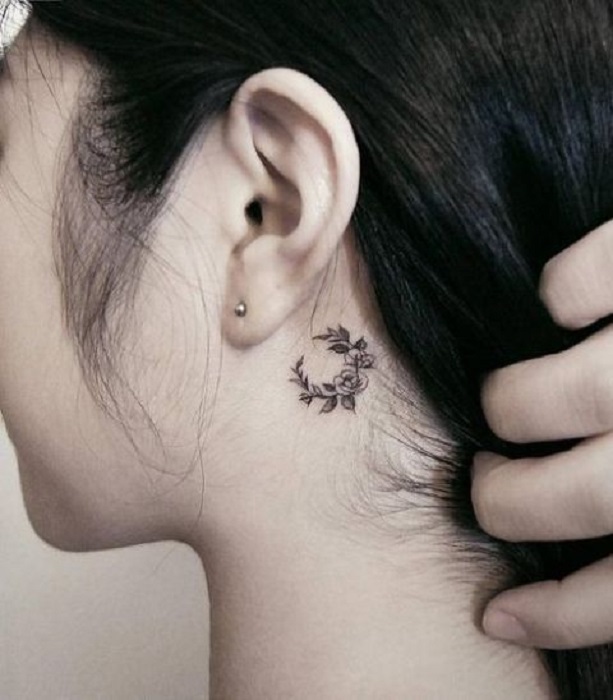 Tatuaje detrás de la oreja de una corona de flores