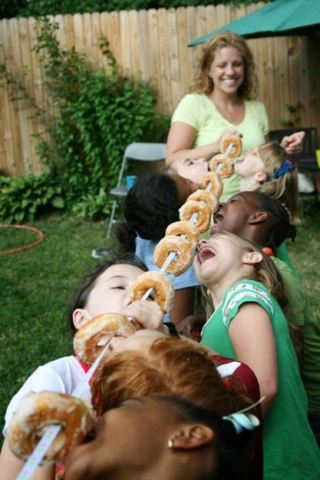 Niños comiendo donas desde una cuerda