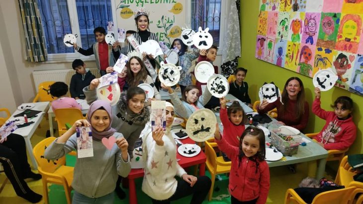 Miss Inglaterra en una escuela para niñas, durante su gira de ayuda