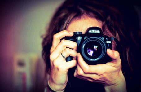 Chica sosteniendo una cámara Nikon