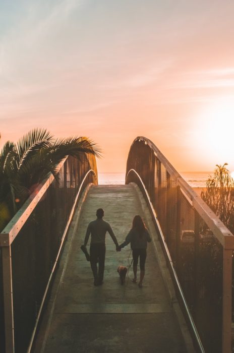Pareja de novios caminando sobre un puente