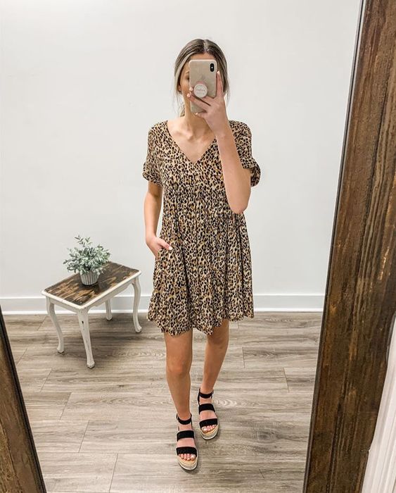 Mujer usa vestido de estampado con sandalias negras