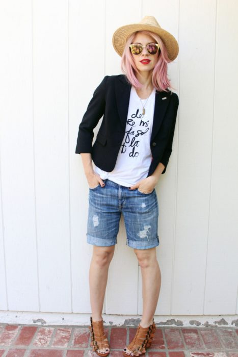 Chica con bermudas de mezclilla, camiseta blanca y blazer negro