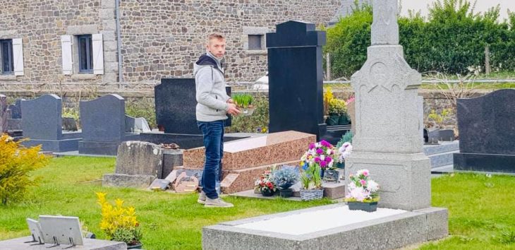 Joven decorando las tumbas del cementerio con flores 