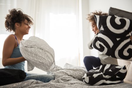 Mamá e hijo en una guerra de almohadas