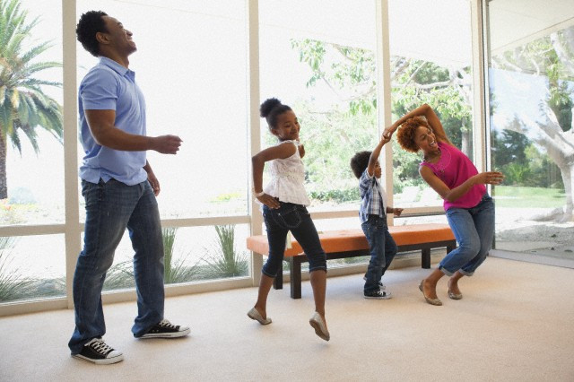 Familia realizando un juego de baile en la sala